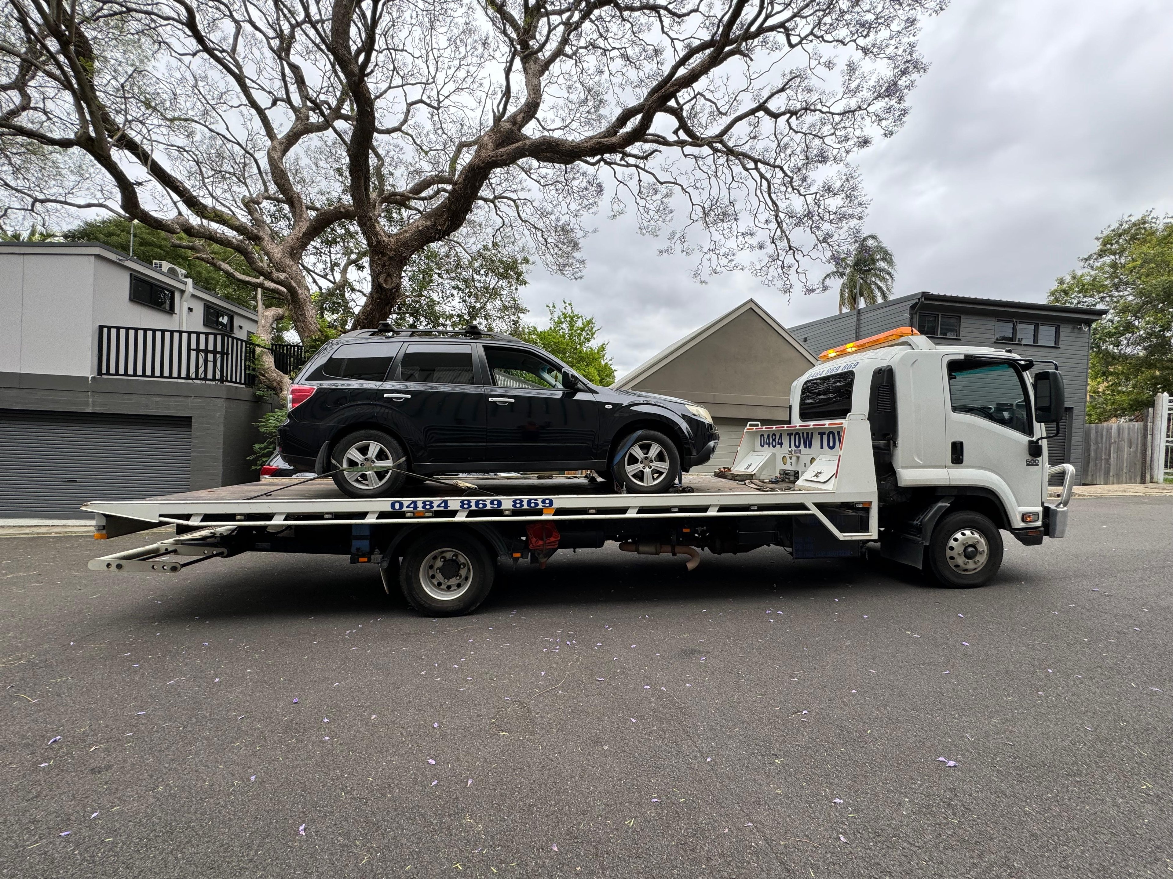 Flatbed tilt tray towing luxury vehicle in Sydney